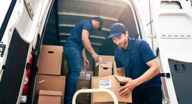 Tasa Amazon de Cataluña: El TS debe analizar el hecho imponible y la cuantificación de la tasa por aprovechamiento especial del dominio público que efectúan los repartidores de los bienes adquiridos a través de comercio electrónico. Imagen de unos chicos sacando paquetes de una furgoneta