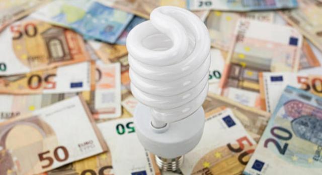 Bizkaia reduce el IVA de la electricidad y suspende el IVPEE para abaratar la factura de la luz. Imagen de una bombilla sobre dinero en metálico