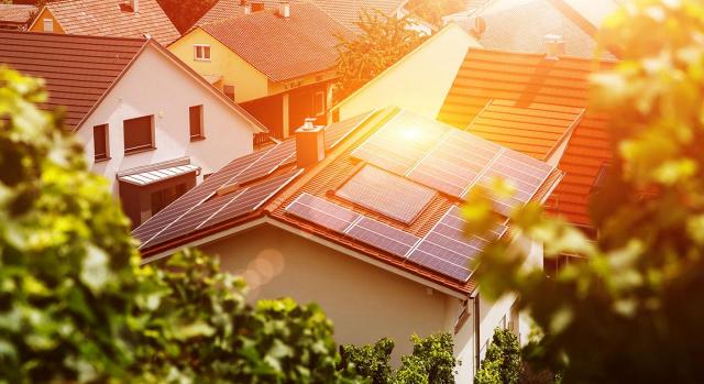 La DGT se pronuncia sobre el IVPEE y el Impuesto sobre la electricidad en las distintas modalidades de autoconsumo eléctrico. Imagen de paneles solares en tejados de casas