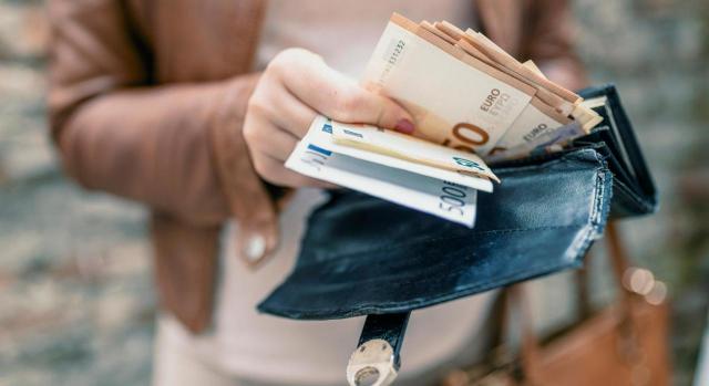 IAE: plazo de ingreso voluntario 2021 cuotas nacionales y provinciales. Imagen de mujer sosteniendo una cartera en las manos con dinero
