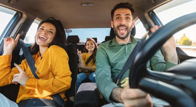 El TS fija como doctrina  que la cesión del uso de un vehículo a los empleados para uso particular está no sujeta al IVA. Imagen de una familia en un coche felices por irse de vacaciones