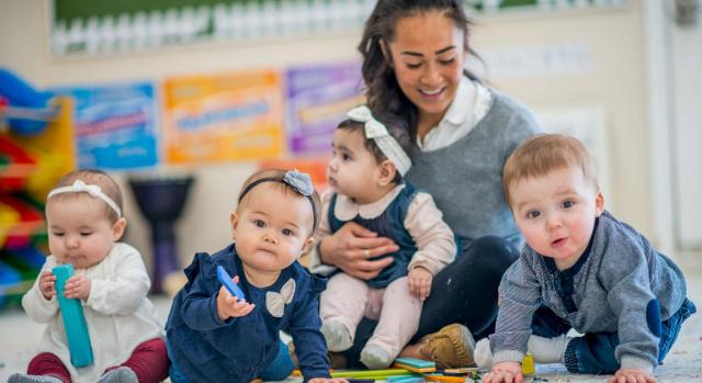 El TS extiende la deducción por maternidad en el IRPF a los gastos de custodia en guardería. Imagen de cuatro niños pequeños con su cuidadora 