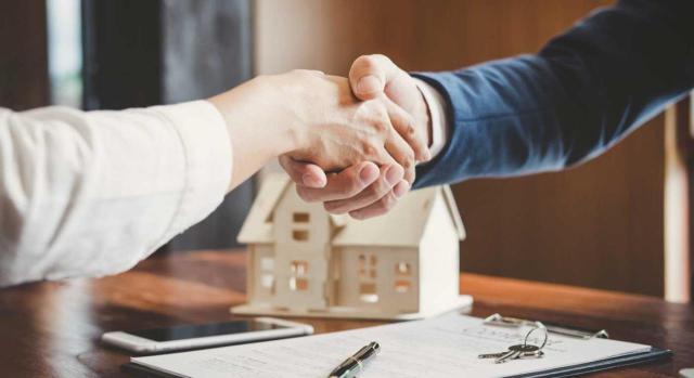 El TEAC y la deducción por inversión en vivienda habitual: se incluyen en la base las cantidades obtenidas en la venta de la vivienda habitual que se destinan a cancelar el préstamo hipotecario que la gravaba. Imagen de dos personas dando un apretón de manos tras la firma de la hipoteca
