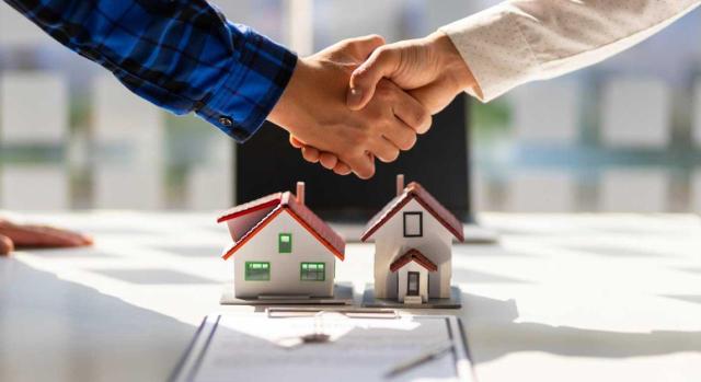 Si una sociedad externaliza o subcontrata la gestión de su actividad principal -arrendamiento de inmuebles-, no significa que incumple los requisitos para su consideración como actividad económica. Imagen de un apretón de manos sobre un contrato de casa