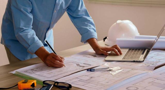 STS: En el IRPF la afiliación en el RETA tiene efectos meramente declarativos y no constitutivos  STS: En el IRPF la afiliación en el RETA tiene efectos meramente declarativos y no constitutivos. Arquitecto dibujando sobre planos en una mesa