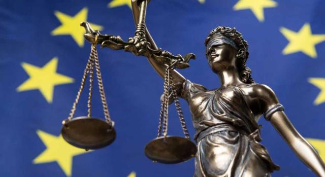 TJUE: Recargo fiscal a no residentes excesivo y contrario a la libertad de circulación de trabajadores. Imagen de la diosa de la balanza sobre el fondo de una bandera de la UE