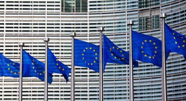 Criptomonedas consejo UE. Fila de banderas de la UE delante de un edificio