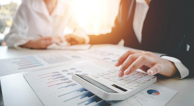 Regularización de las bases imponibles negativas basada en otra liquidación no firme Se pueden regularizar las bases imponibles negativas declaradas en un ejercicio basándose en una liquidación de ejercicios anteriores no firme. Imagen de una mesa de escritorio con gráficos y una calculadora