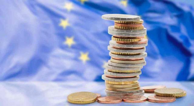 Bizkaia, transposición, asimetrías híbridas invertidas, BEPS, OCDE Bizkaia, transposición, asimetrías híbridas invertidas, BEPS, OCDE. Un montón de monedas apiladas y de fondo la bandera de la UE