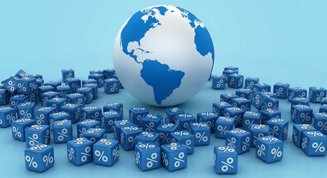 Cálculo del límite de la deducción por doble imposición internacional en IS: una entidad de explotación de hidrocarburos no aplicará el 30%, sino el 25% si forma parte de un grupo fiscal. Imagen de una bola del mundo y cubos con porcentajes a su alrededor