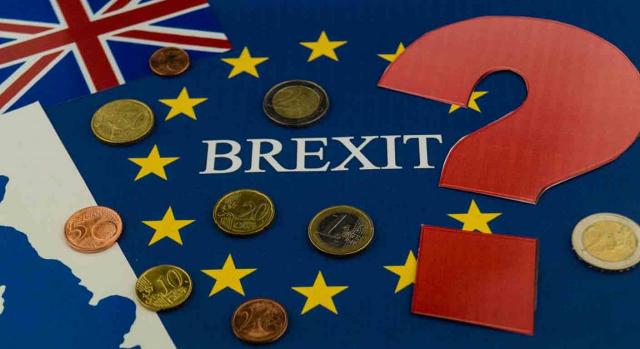 Devolución IVA Brexit. Palabra Brexit sobre la bandera del Reino Unido, la CEE, unas monedas y un signo de interrogación