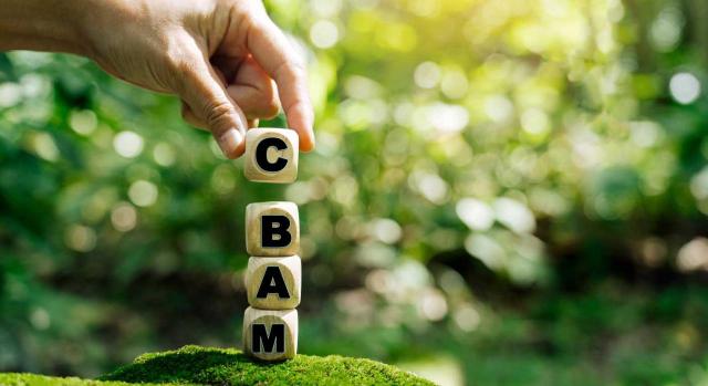 Se modifica el Reglamento (UE) 2023/956 en lo que respecta a la simplificación y el refuerzo del Mecanismo de Ajuste en Frontera por Carbono. Imagen de unos dados con las letras C, B, A, M sobre un fondo verde