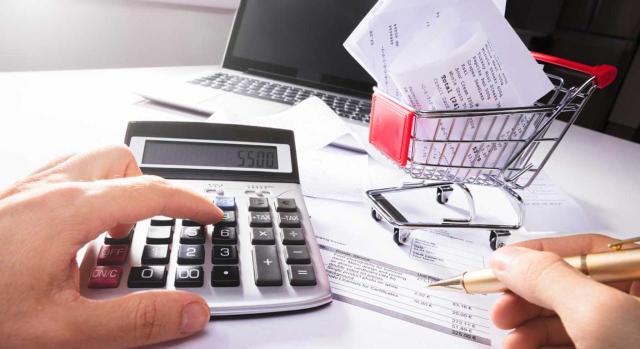 Prorrata en el IVA: gastos obligatorios, vínculo directo y límite del concepto de gasto general en el ejercicio de operaciones con y sin derecho a deducción. Imagen de un hombre haciendo cuentas sobre los tickets del carro de la compra