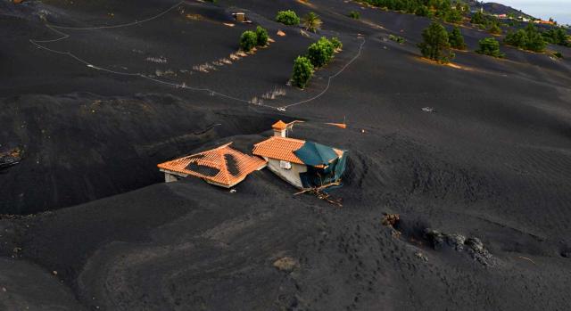 Se prorroga la deducción en IRPF por residencia habitual y efectiva en la isla de La Palma para 2025. Imagen de una casa rodeada de lava en la isla de La Palma