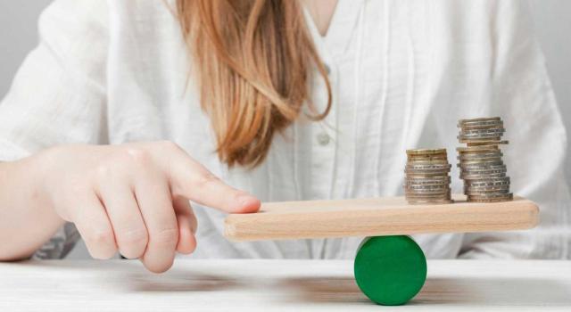 Los rendimientos negativos de otras actividades no se computan para aplicar la exención de las participaciones empresariales en el IP Los rendimientos negativos de otras actividades que no constituyen la fuente de las funciones directivas no pueden integrar el denominador del cálculo del porcentaje exigido para aplicar la exención de las participaciones en el IP. Imagen de una chica con una balanza hecha por una tabla y un circulo verde de madera en el que hay monedas sosteniendose sobre ella