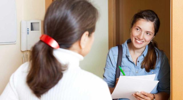 Anulación de comprobaciones de valores en el IRPF por falta de visita personal del perito al inmueble, que exige el reconocimiento directo para garantizar una motivación suficiente. Imagen de una chica llamando a la puerta de otra ofreciendole algo