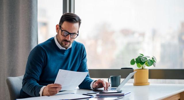 CNAE asesores fiscales. Imagen de un hombre leyendo en un escritorio