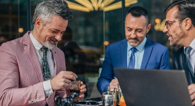 IP exención de participaciones en entidades: la persona contratada a jornada completa es un familiar. Imagen de unos hombres tomando café tras una comida de trabajo