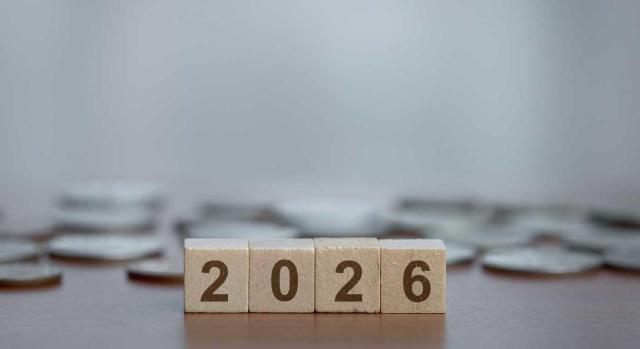 Bizkaia aprueba los presupuestos para 2026 y actualiza las cuantías de los beneficios fiscales y la tarifa del IRPF y aprueba una nueva regulación de la Tasa de prevención, extinción de incendios y salvamento. Imagen de bloques de madera con monedas de fondo poniendo 2026