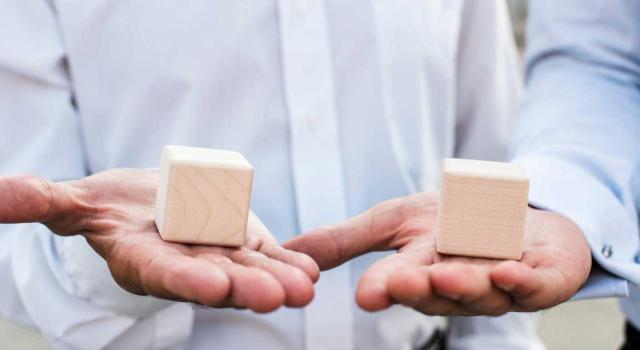 La responsabilidad tributaria subsidiaria se extingue por el fallecimiento del responsable, su naturaleza sancionadora impide la transmisión mortis causa a sus herederos. Imagen de las manos de un hombre con un cubo de madera en cada mano