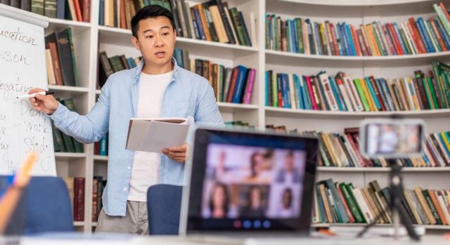 IRPF: impartición de cursos online. Profesor dando clase con una pizarra frente a un monitor 