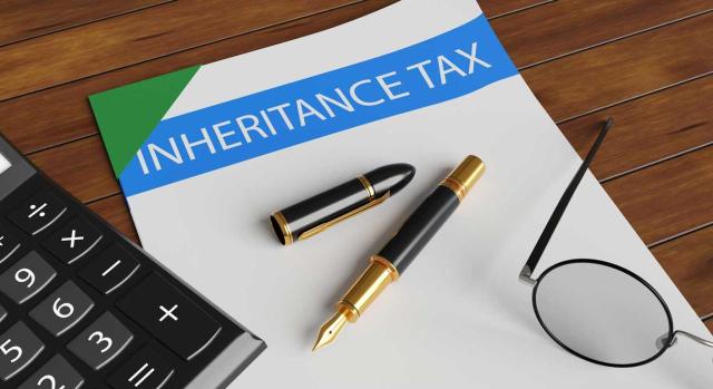 Renuncia a la herencia: implicaciones fiscales que todo asesor debe conocer. Imagen de una carpeta de documetnos, una calculadora y un boligrafo sobre una mesa de madera