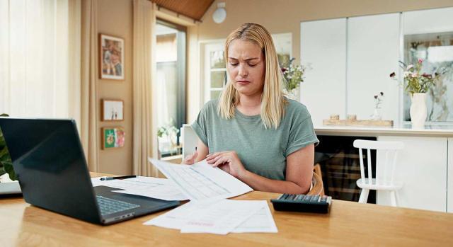 Debe anularse la regularización efectuada por la Administración ya que la factura rectificativa y la reclamación de pago se remitieron a un domicilio erróneo y no se ha acreditado la recepción por el actor que no es sujeto pasivo del IVA. Imagen de una chica mirando unos papeles con cara de preocupación viendo que está erroneos