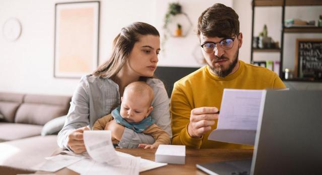 El domicilio fiscal tiene una gran importancia en el IRPF. Imagen de joven familia estudiando impuestos y facturas