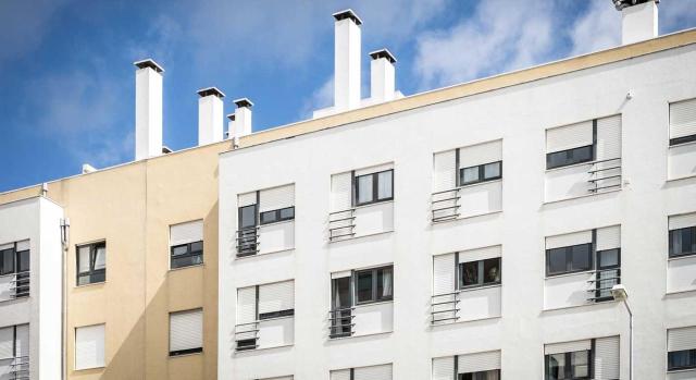 Aplicación del tipo reducido del 2% en TPO a la adquisición de una vivienda por una empresa cuya actividad principal en el IS el CNAE de agencia de publicidad, pero acredita que el grueso de su beneficio procede de la compraventa de inmuebles. Imagen de un edificio de pisos