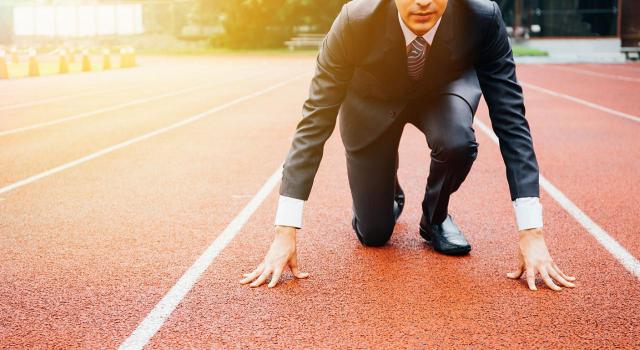 Incentivos fiscales recogidos en la Ley de fomento del ecosistema de empresas emergentes (Ley de Startups). Imagen de un hombre de negocios preparandose a correr en una pista de atletismo