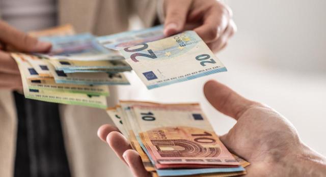 Álava modifica en su reglamento del IRPF las retenciones aplicables a los rendimientos de trabajo. Imagen de traspaso de dinero entre dos personas
