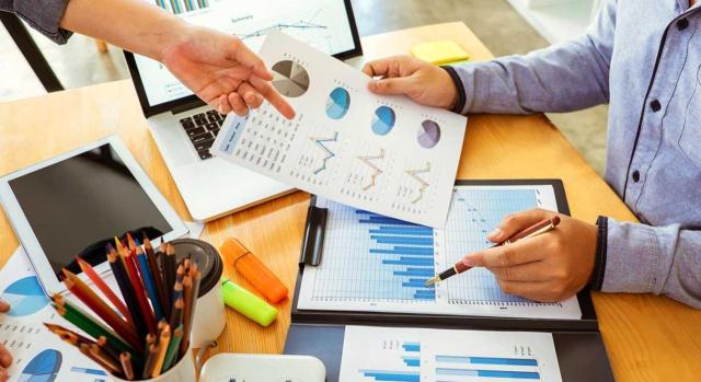 IS créditos incobrables frente a un fallecido: diferenciación entre deterioro del crédito y baja contable. Imagen de una mesa de trabajo mientras están estudiando varias gráficas