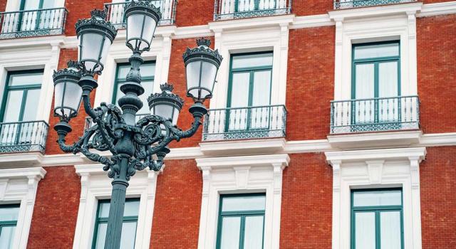 La consulta tributaria expuesta –V1656-25, de 16 de septiembre de 2025- parte de una comunidad de propietarios que encargó la reparación de un cerramiento dañado Qué debe hacerse cuando el contratista aplicó el 21% de IVA en vez del 10% en el caso de unas obras de reparación en una comunidad de propietarios. Imagen de una farola enfrente de un edificio de pisos