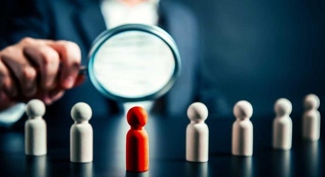 Las pérdidas patrimoniales de la empresa quebrada de un causahabiente no pueden aplicarse en la declaración de IRPF del heredero. Imagen de un hombre mirando con lupa unas fichas