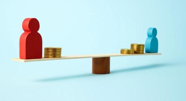 Limitación de BINS en entidad inactiva Limitación a la compensación de BINs tras la adquisición de entidades inactivas y consecuencias en los procesos de fusión. Imagen de unas figuras balanceandose con monedas