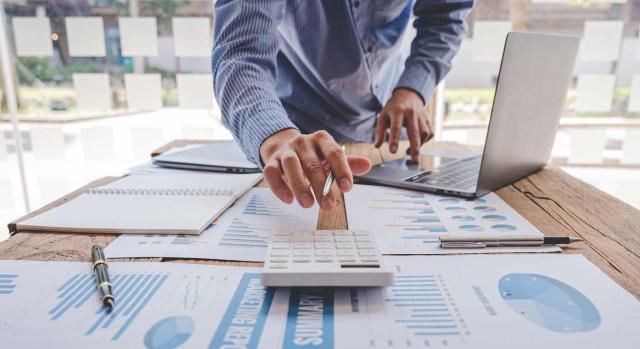 El TS debe determinar si en la imputación temporal de los ajustes por operaciones vinculadas respecto a una sociedad profesional y su socio debe seguirse el criterio del IS o del IRPF. Imagen de un hombre hechando cuentas