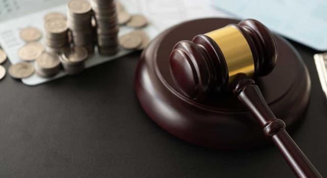 El Tribunal Supremo reitera que si el órgano jurisdiccional considera que no procede la suspensión de la deuda tributaria garantizada en vía administrativa, deberá reforzar la motivación para denegar la suspensión. Imagen del mazo de un juez y dinero a su izquierda