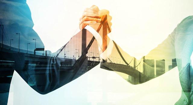 IS fusión por absorción motivada por la crisis inmobiliaria IS fusión por absorción motivada por la crisis inmobiliaria. Dos personas de negocios dándose un apretón de manos