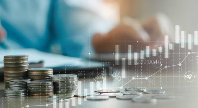 El TC reitera la constitucionalidad de la regulación de los pagos fraccionados de las grandes empresas (aquellas con cifra de negocios superior a 10 millones de euros) en el IS. Imagen de un hombre haciendo sus cuentas empresariales con gráficos y montoncitos de dinero