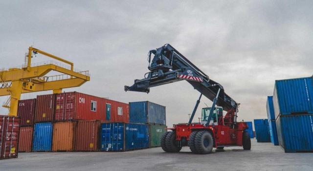 No procede exención de derechos de aduana cuando se exporta mercancía a través de un Estado que no figura en la autorización de perfeccionamiento pasivo No procede la exención de los derechos de aduana cuando la mercancía se exporta a través de un Estado miembro que no figura en la autorización de perfeccionamiento pasivo. Imagen de una grua en un muelle de contenedores de carga