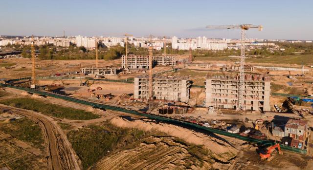 ¿Está sujeta a IVA la expropiación del sobrante del aprovechamiento de los terrenos reservado de una previa operación sujeta y exenta de IVA? ¿Está sujeta al IVA y no exenta la expropiación del sobrante del aprovechamiento reservado por ser una operación diferenciada de la entrega de terrenos para viales públicos? Imagen de una construcción de edificios con gruas