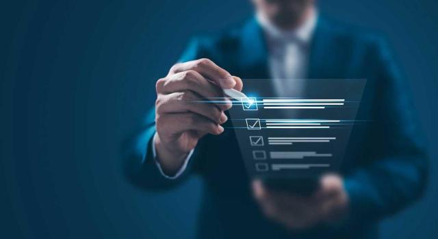 Relación de entidades presentadoras de los Informes de Transparencia Fiscal Empresarial. Imagen de un hombre chequeando un listado digitalmente