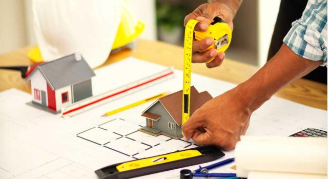 La DGT cambia de criterio adaptándose a lo señalado por el TS: no es exigible la cédula de habitabilidad para poder aplicar el tipo del 10% de IVA, como cuando se transforma un local en una vivienda. Imagen de un hombre midiendo una casita hecha a escala