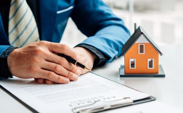 IVA no exento: cesión de piso a empresa para su alquiler IVA no exento: un no residente cede un piso en España a una empresa que lo arrendará a terceros en nombre propio con fines turísticos. Imagen de un hombre preparado para firmar el contrato de una casa