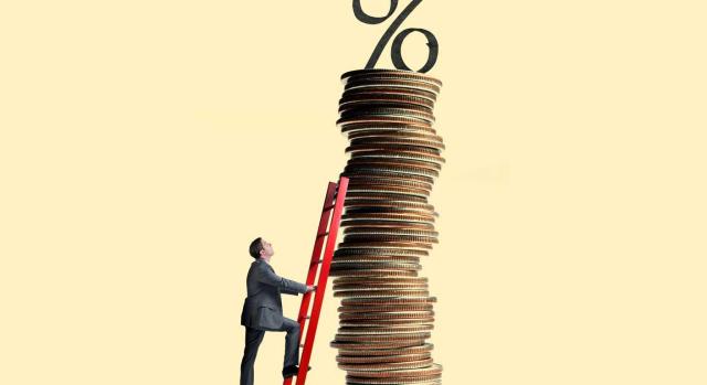 Gipuzkoa: Impuesto sobre el margen de intereses y comisiones de determinadas entidades financieras Gipuzkoa aprueba su norma foral del Impuesto sobre el margen de intereses y comisiones de determinadas entidades financieras. Imagen de un hombre poniendo una escalera en una super torre de monedas con el simbolo del porcentaje en la cima