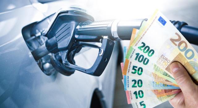 El TJUE declara ilegal el tramo autonómico del impuesto especial sobre hidrocarburos puesto que carece de la finalidad específica. Imagen de una mangera rellenando combustible en un automóvil con billetes en la mano