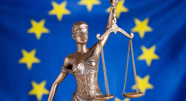 Imagen de la dama de justicia con su balanza y la bandera europea de fonto