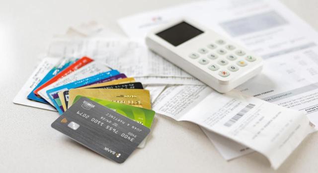 ISD: liquidación de la consolidación del dominio sobre cuentas corrientes que no existen fallecido el usufructuario ISD: liquidación de la consolidación del dominio sobre cuentas corrientes que no existen fallecido el usufructuario. Primer plano de un montón de tarjetas de crédito y recibos junto a un extracto bancario