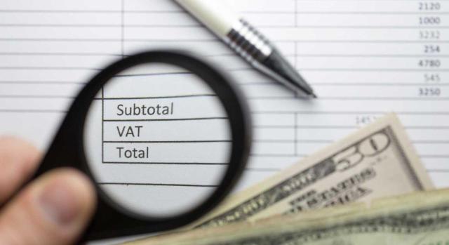 La entrega gratuita a clientes de bienes sin carácter profesional no determina la deducibilidad del IVA soportado por su adquisición. Imagen de una lupa examinando los conceptos de una factura