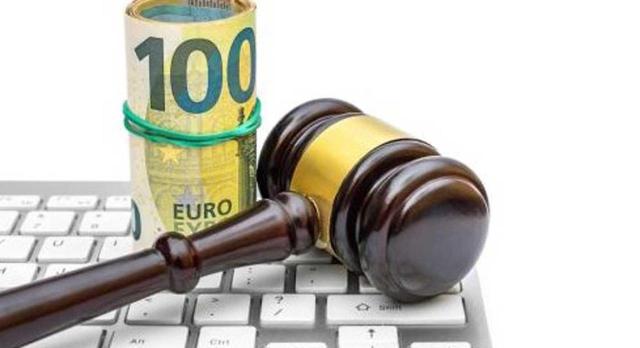 Proyecto de Orden: modificación modelo 718 Impuesto Temporal de Solidaridad de las Grandes Fortunas. Imagen de un mazo y billetes de euros sobre un teclado de ordenador